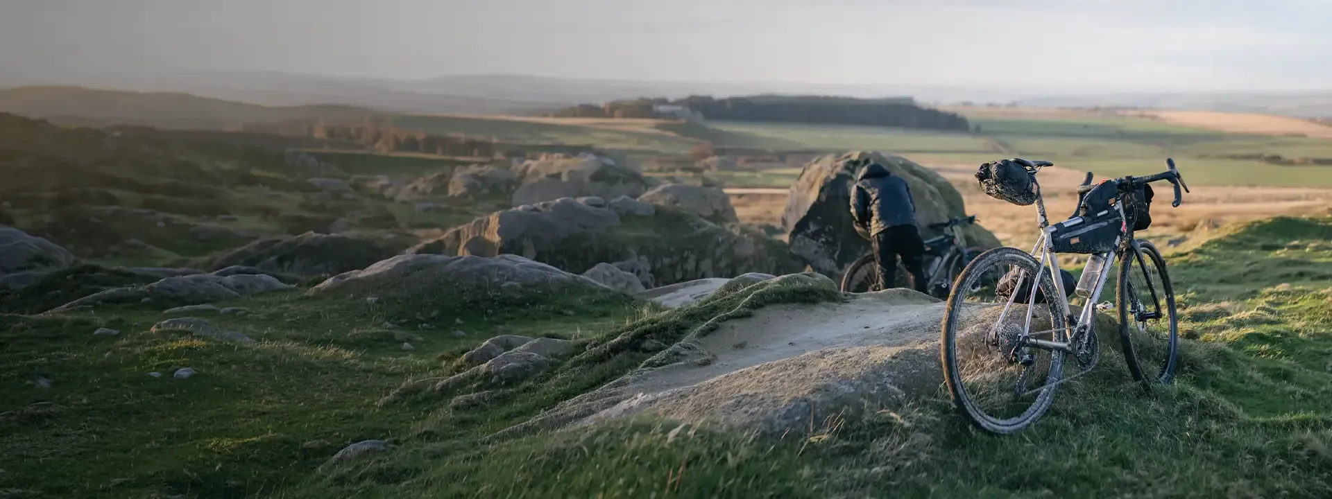 Road bike beside a rocky outcrop overlooking open moorland