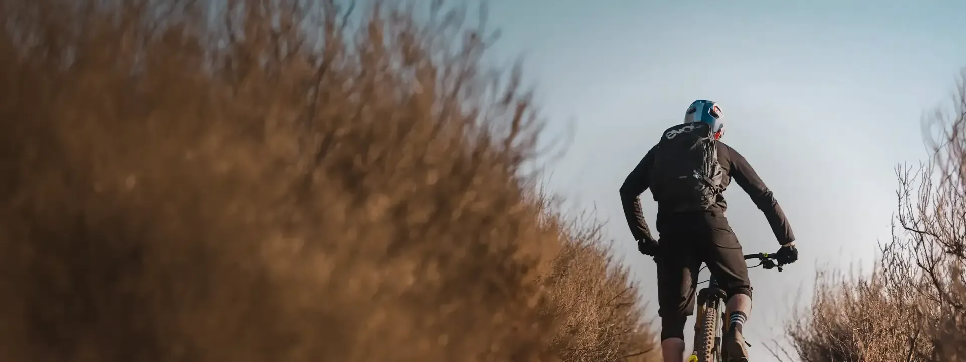 Mountain biker riding on a trail with a cycling backpack