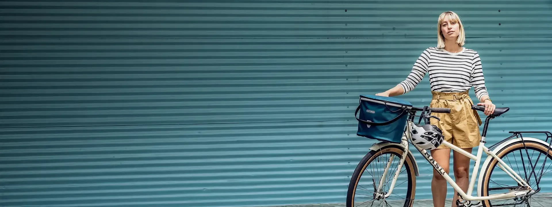 Rider standing beside a city bike fitted with a front basket