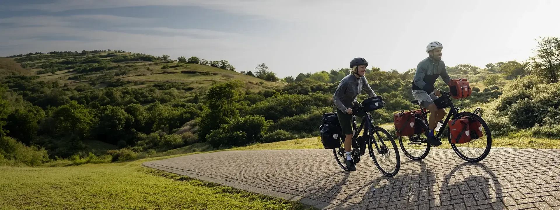 Two touring cyclists riding with Ortlieb panniers and front bags