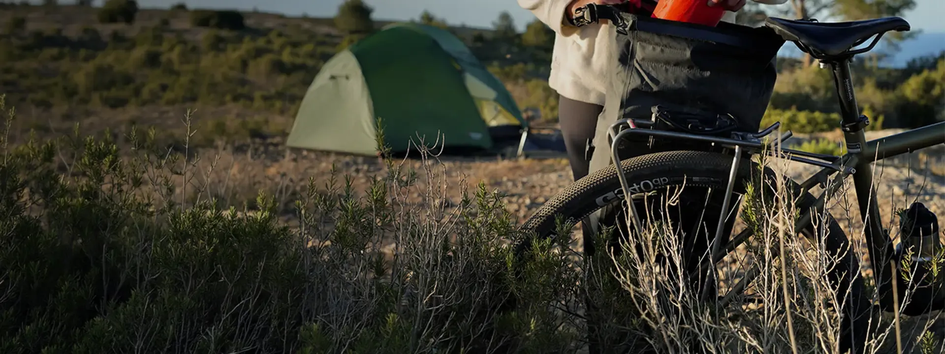 Touring bike fitted with a Tubus rear rack and luggage beside a tent
