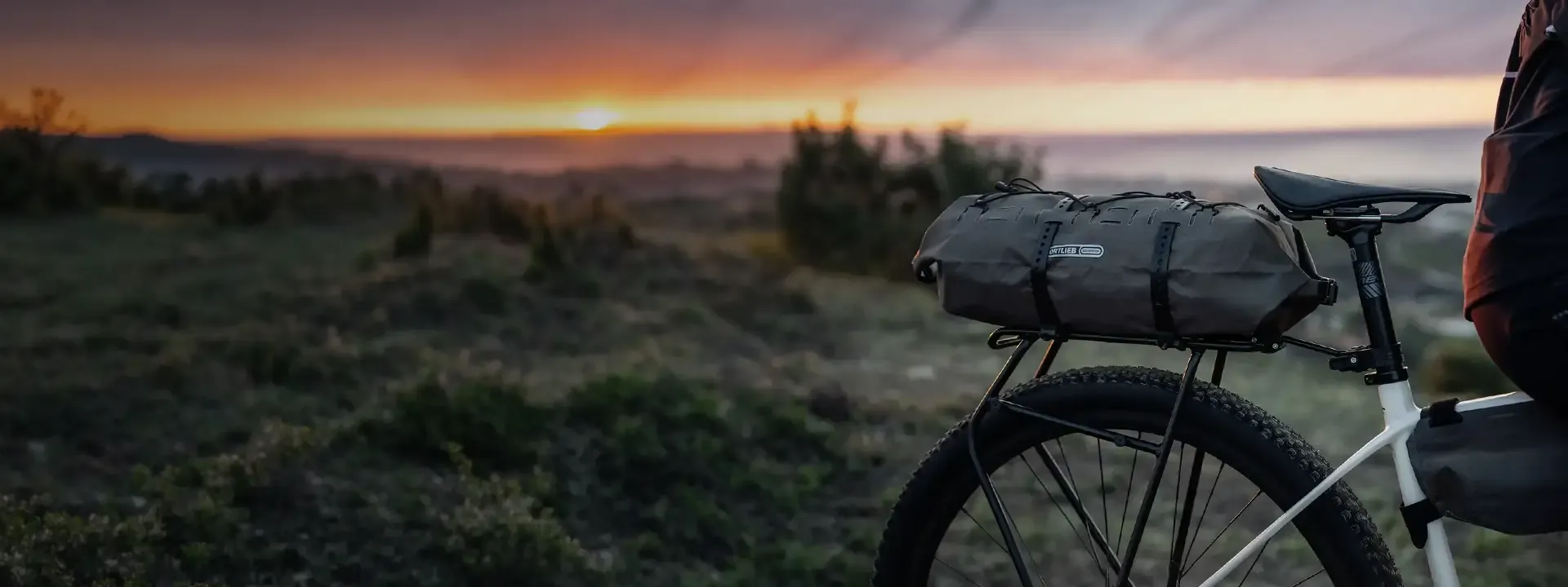 Bike fitted with a large rear rack bag at sunset