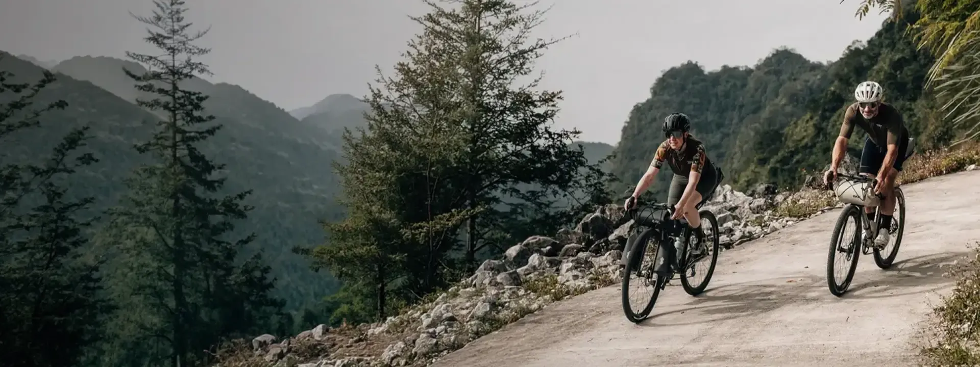 Two gravel cyclists riding with bikepacking bags on a mountain road