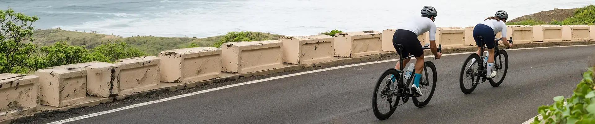 Road cyclists wearing cycling bib shorts in an aero tuck on a descent