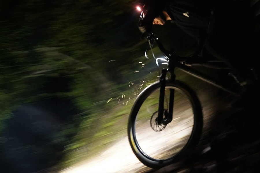 Mountain bike front light illuminating a dark trail