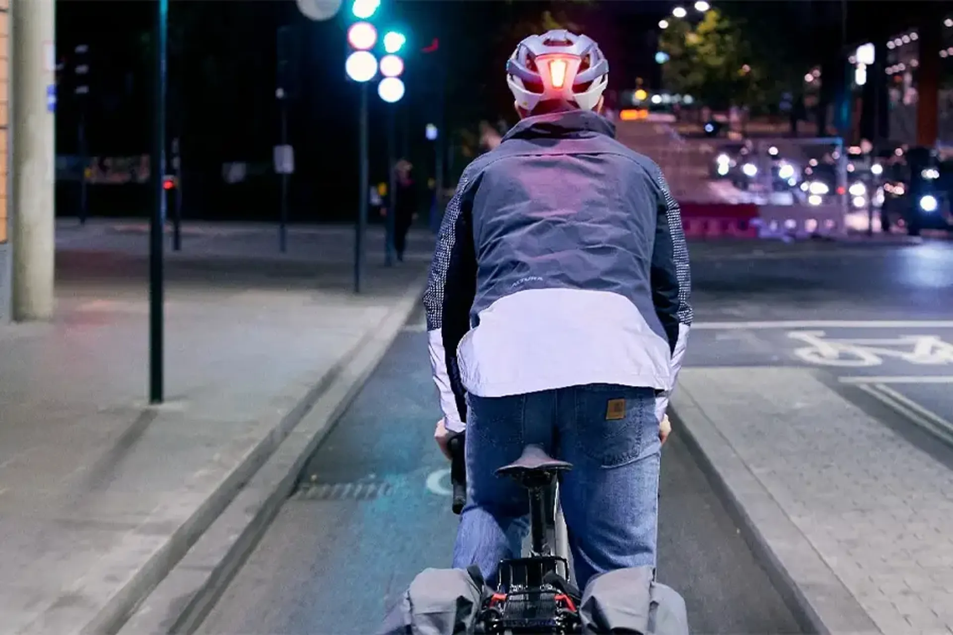Cyclist wearing reflective clothing on a city street at night