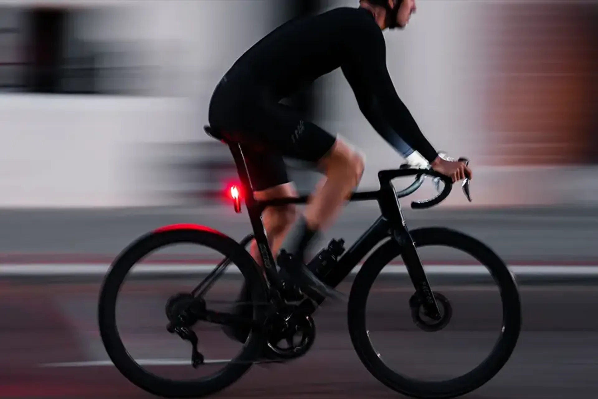 Road cyclist using front and rear lights in low light