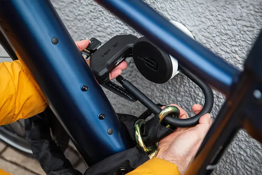 E-bike secured to a ground anchor with a D-lock and chain at home