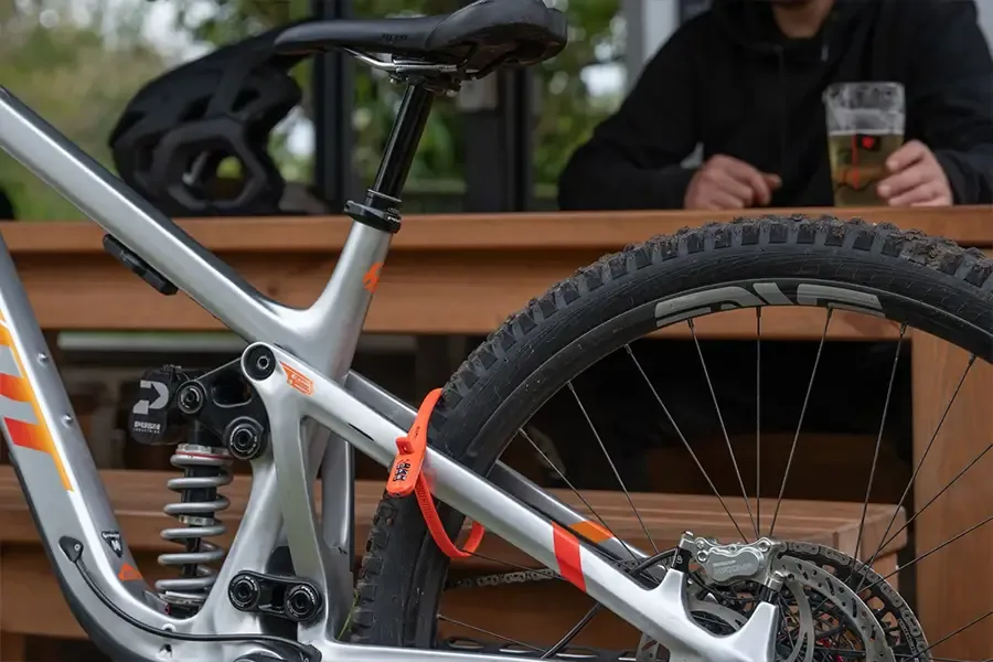 Cable lock securing a bike with its owner at a table nearby