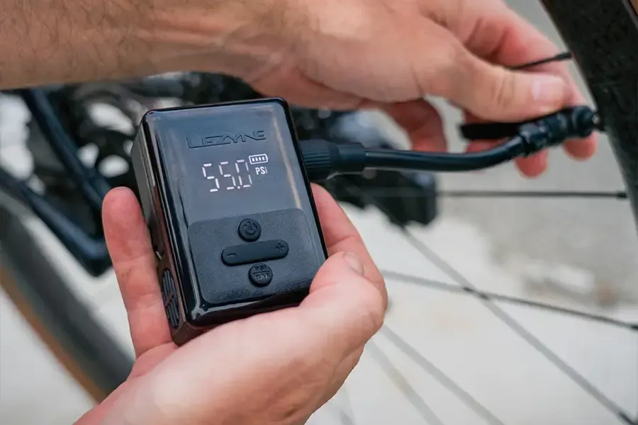 Pumping up a bike tyre with an electric mini pump set to 55 PSI
