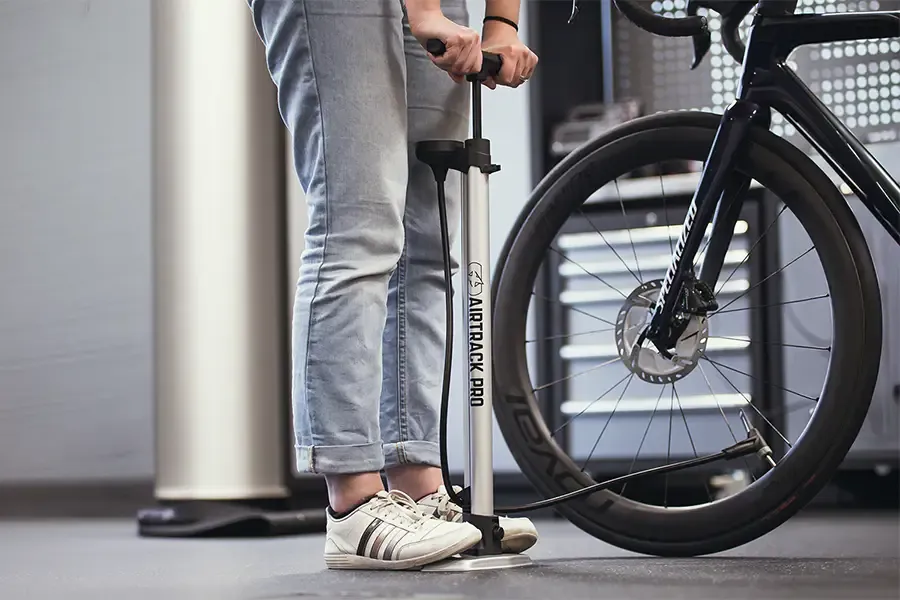 Pumping up the tyres on a Specialized road bike using a track pump
