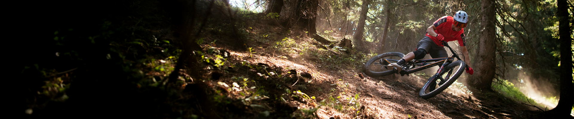 Mountain bike rider shredding a flat turn in the woods wearing body armour
