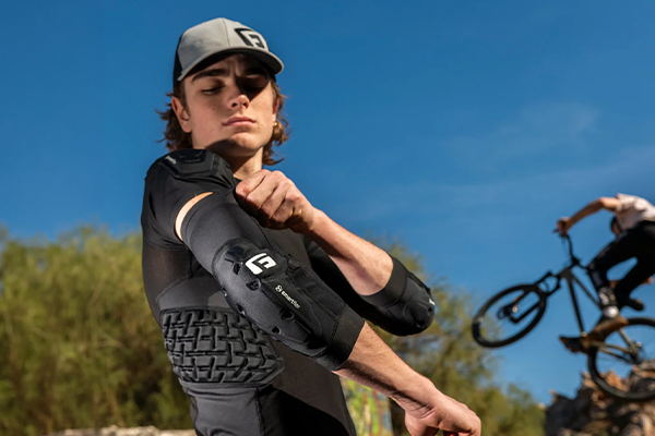 Mountain bike putting on elbow pads before riding