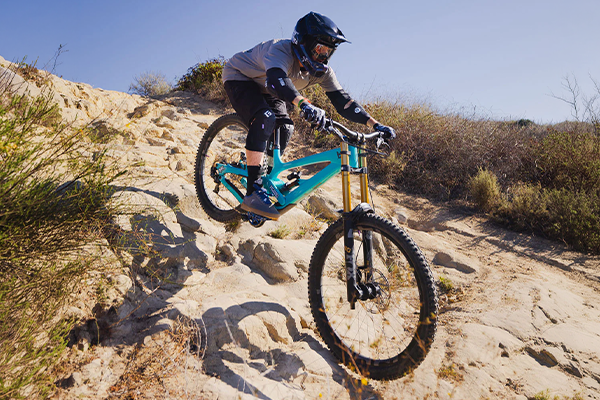 Mountain bike rider wearing G-Form knee and elbow pads on rocky downhill track