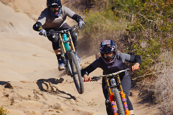 Mountain bikers wearing G-Form torso protection, pads & full face helmets on a fast DH track