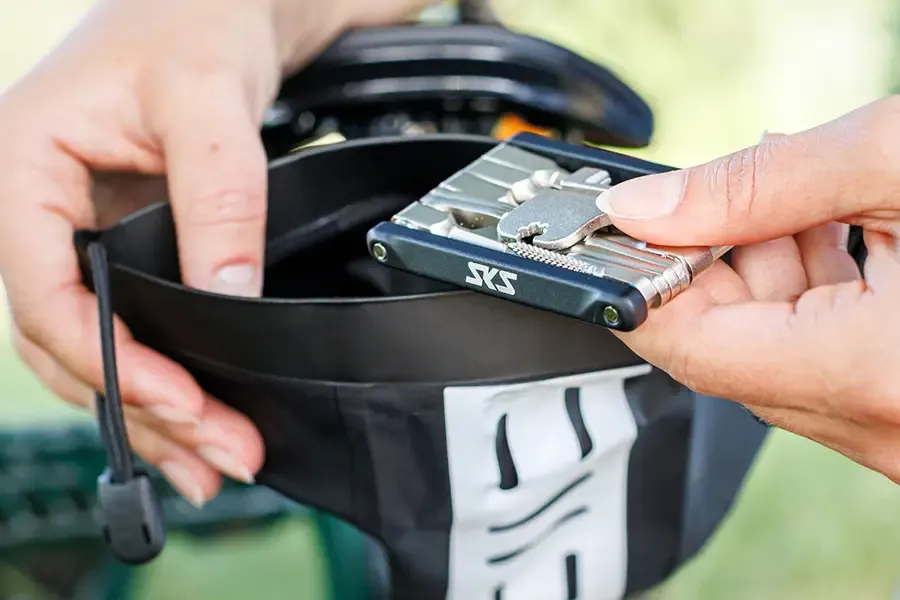 A compact multi-tool being packed into a saddle bag