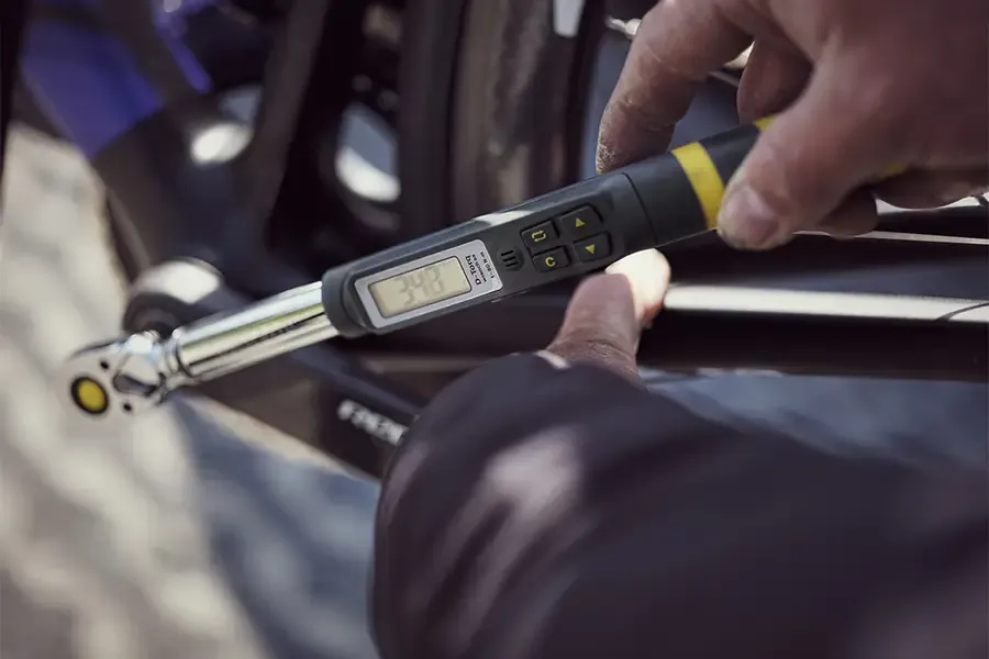 A digital torque wrench being used on a bicycle