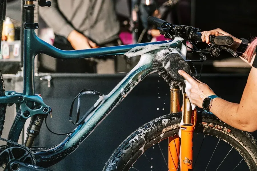 A bicycle being gently cleaned outdoors