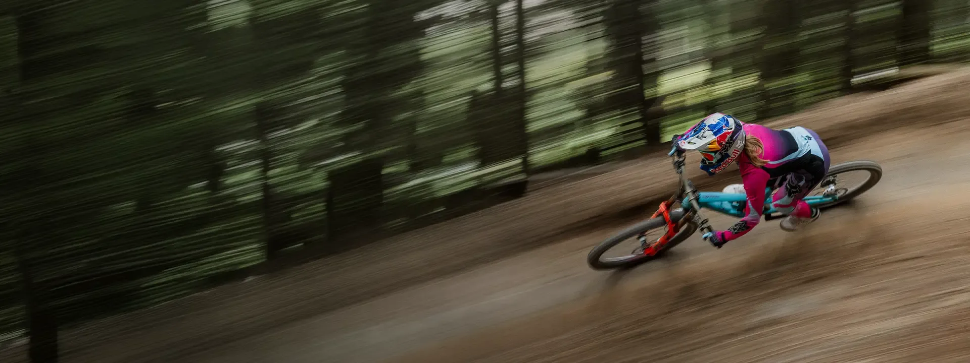 Mountain biker wearing Fox equipment while cornering at speed on a forest trail
