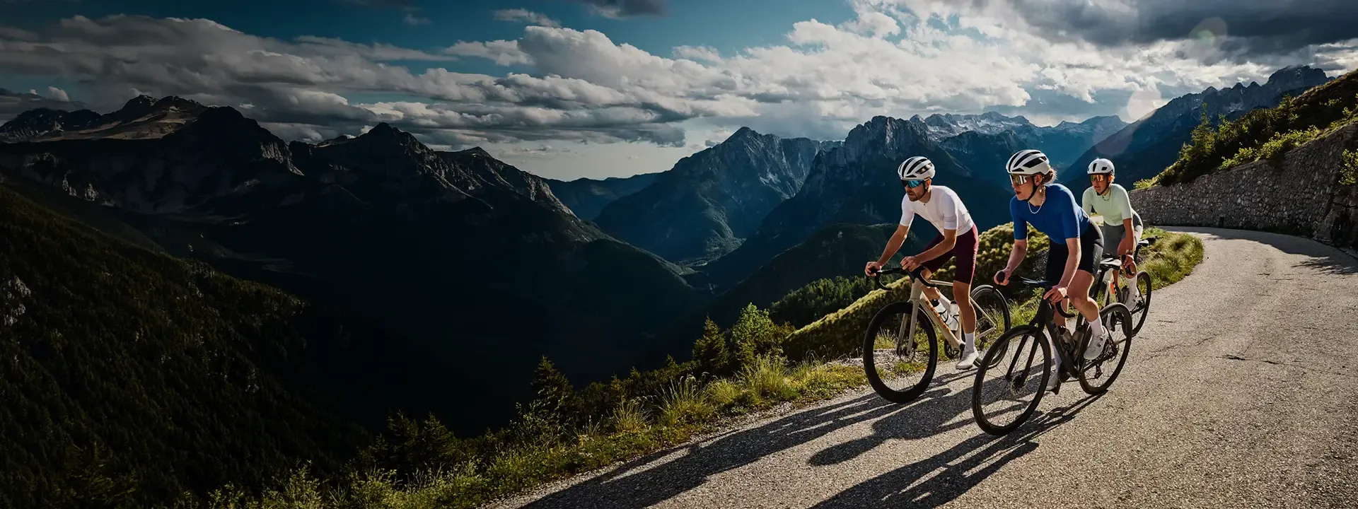 Three road cyclists climbing a high mountain pass