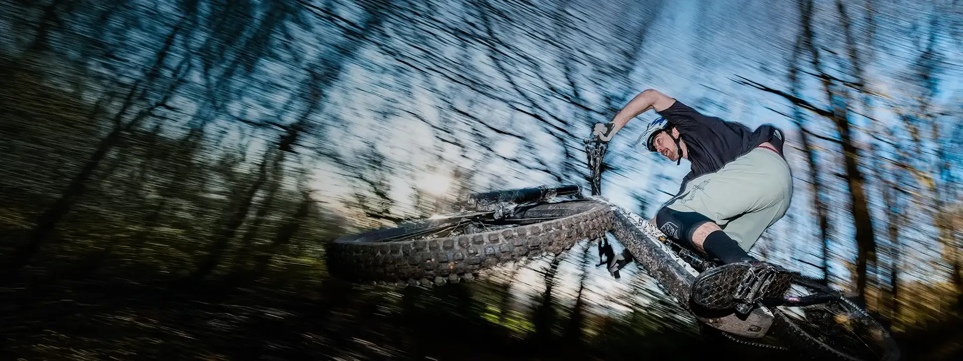 Mountain biker leaning the bike through a fast forest corner