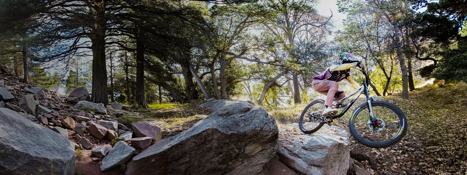 Mountain biker dscrubbing a drop on a rocky downhill trail