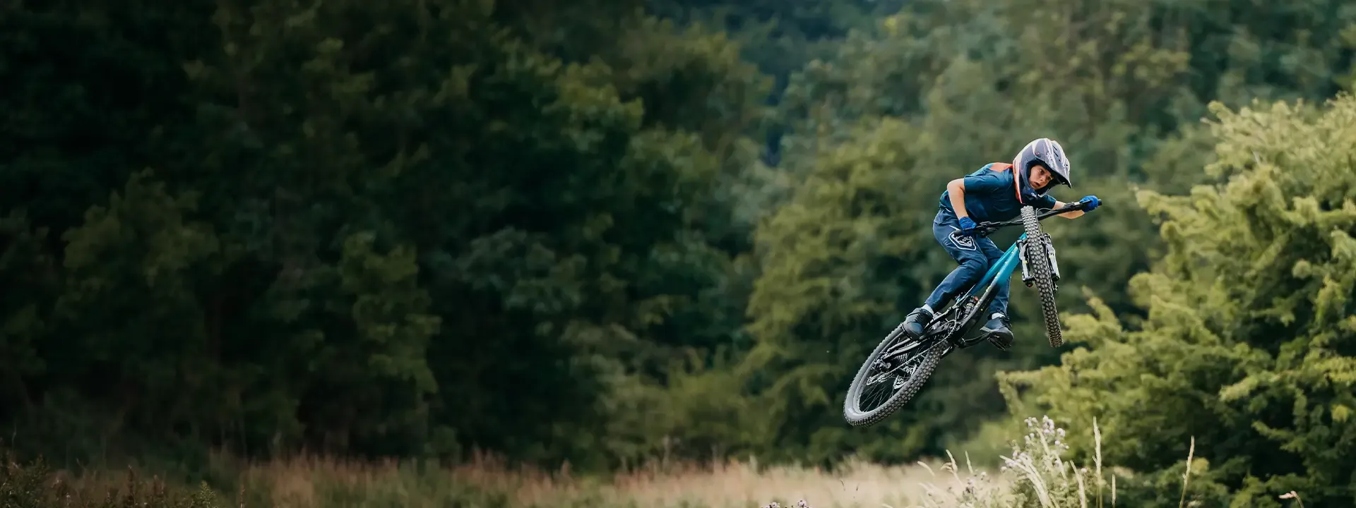 Young mountain biker riding in kids cycling clothing
