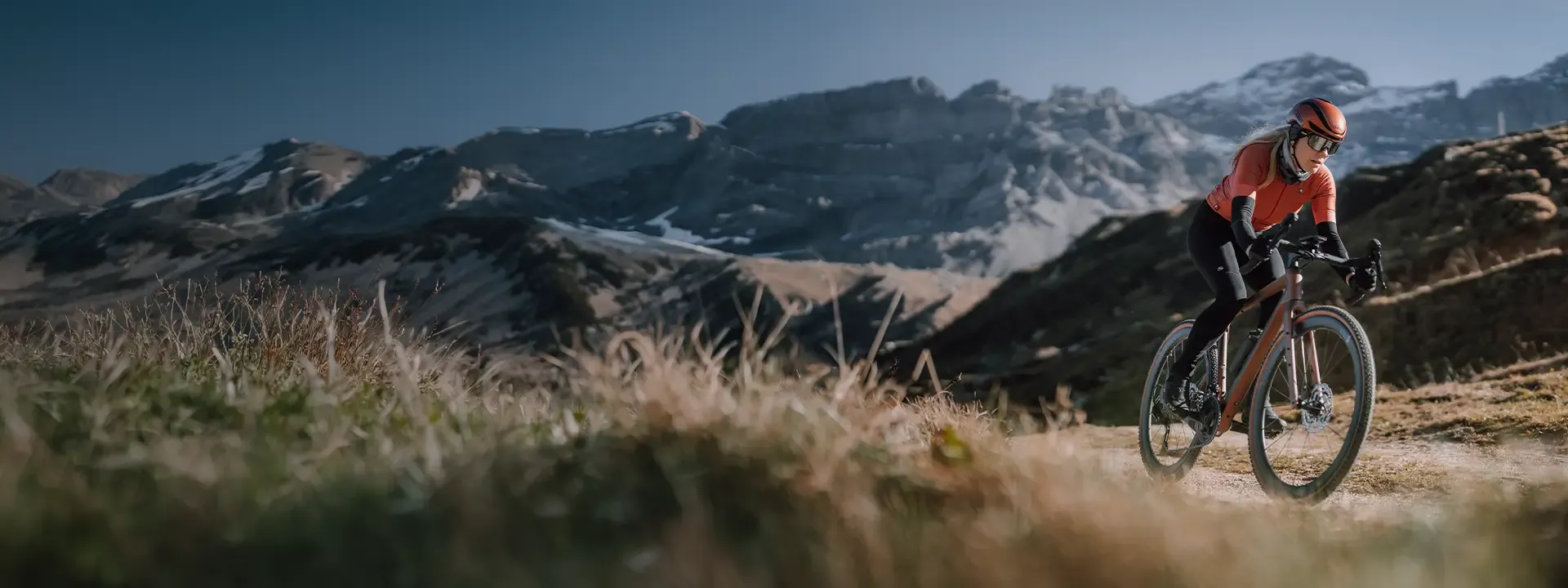 Gravel cyclist riding through mountain terrain wearing thermal cycling bib tights in cold weather conditions