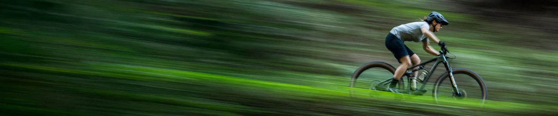 Female mountain bike rider cycling fast wearing MTB clothing