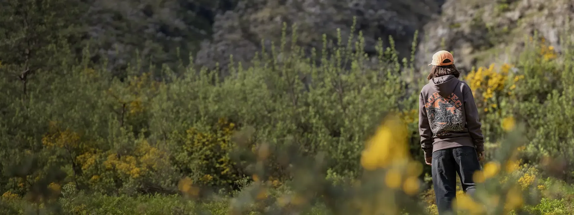 Mountain biker wearing a casual riding hoodie in an outdoor trail setting