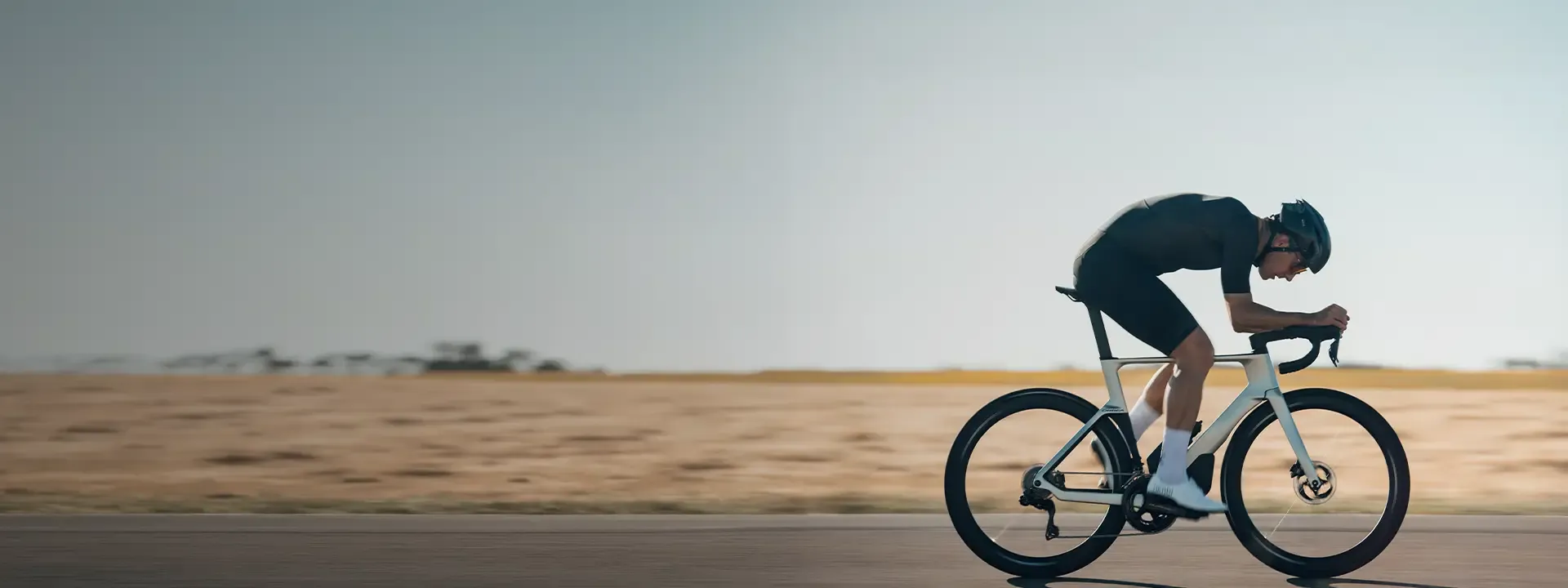 Road cyclist riding in an aerodynamic cycling speed suit during high speed performance riding