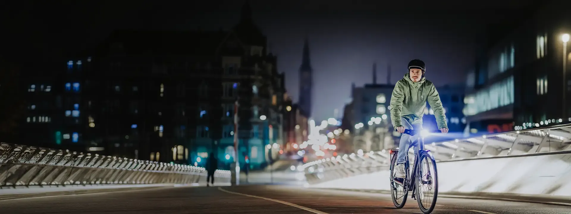 Commuter cyclist riding at night in practical cycling clothing