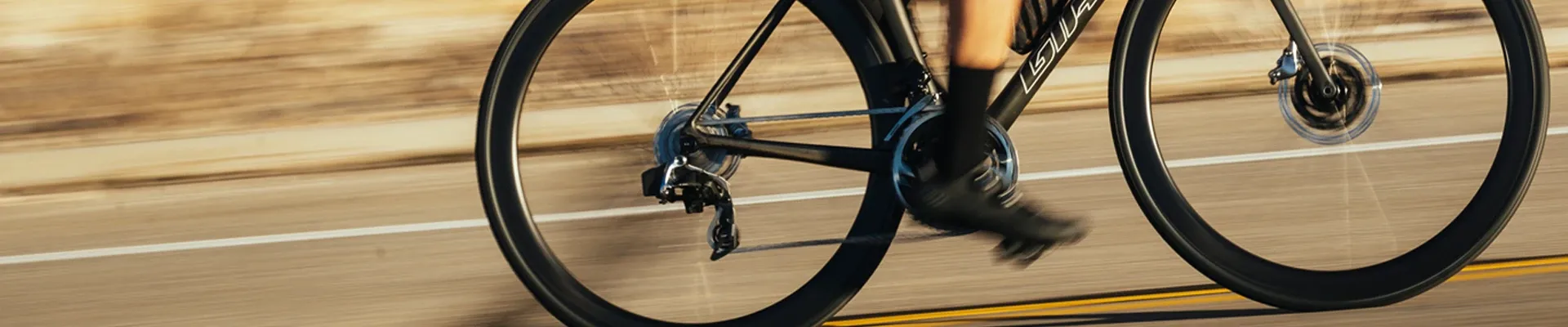 Giant road bike ridden at speed detail showing the drivetrain, wheels and brakes