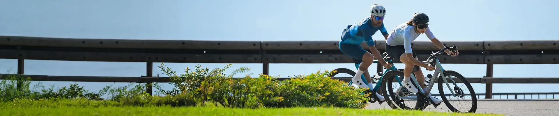 Male and female cyclists on Cube Agree carbon road bikes cornering on a fast training ride