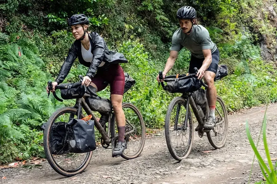 Two bikepacking riders on gravel bikes carrying multiple bags