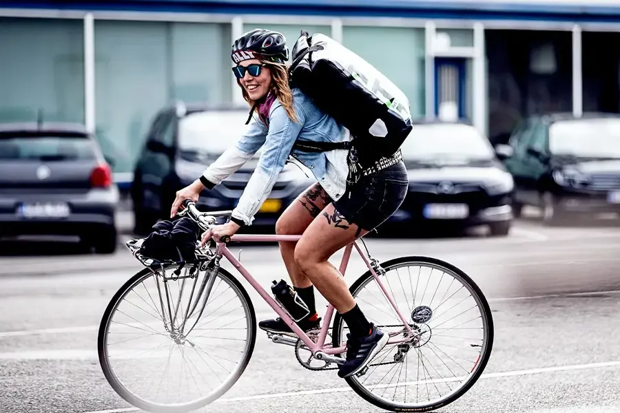 Woman riind gin an uraban setting with a cycling messenger bag