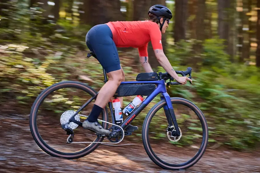 Woman riding a gravel bike fitted with compact cycling luggage