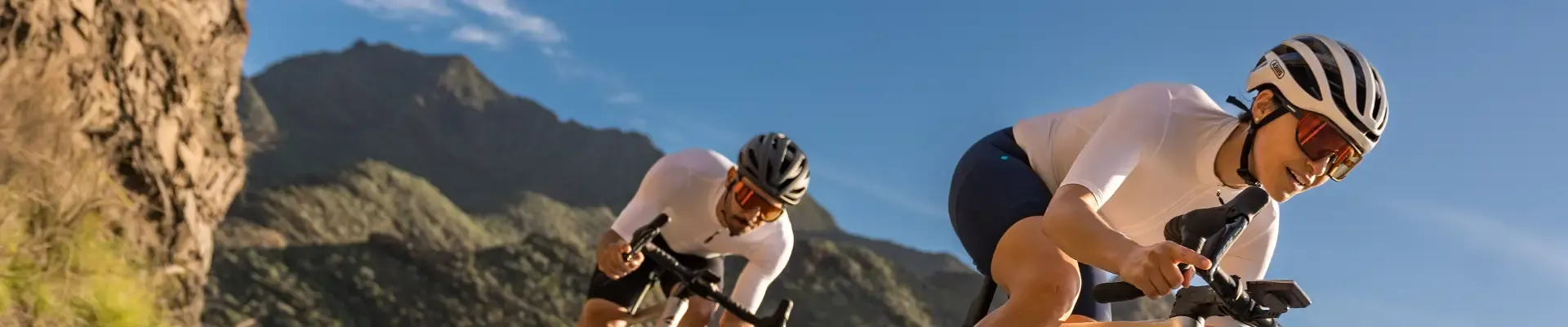 Two road cyclists wearing tinted riding glasses on a sunny ride