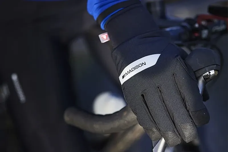 Road cyclist wearing waterproof gloves clos-up on drop handlebars