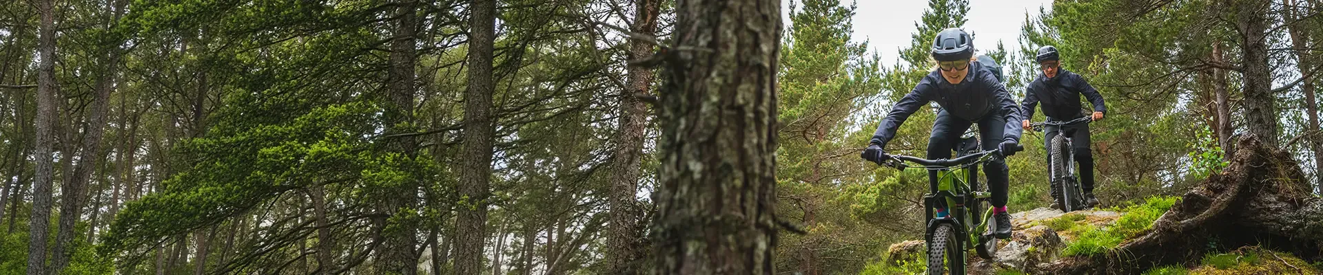 Mountain bikers wearing waterproof jackets riding technical trails