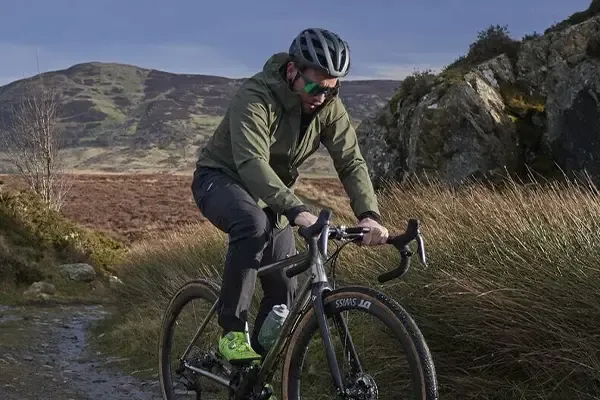 Gravel cyclist wearing a lightweight windproof cycling jacket