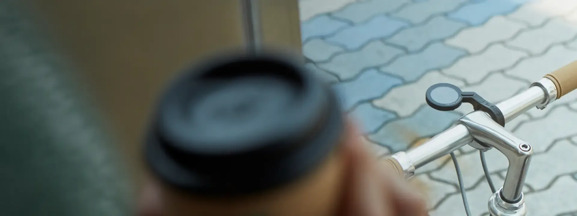 Wireless cycle computer mounted on a city bike handlebar with a takeaway coffee in the foreground