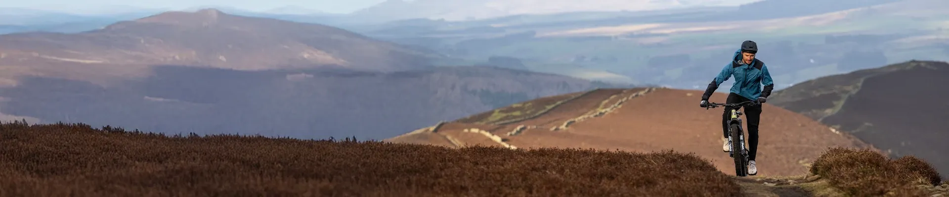 Electric mountain bike riding up a climb in hilly terrain