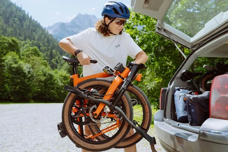 Lifting an Electric folding bike folded into the back of a car