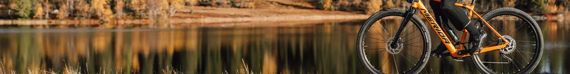 electric gravel bike riding past a lake with refelections
