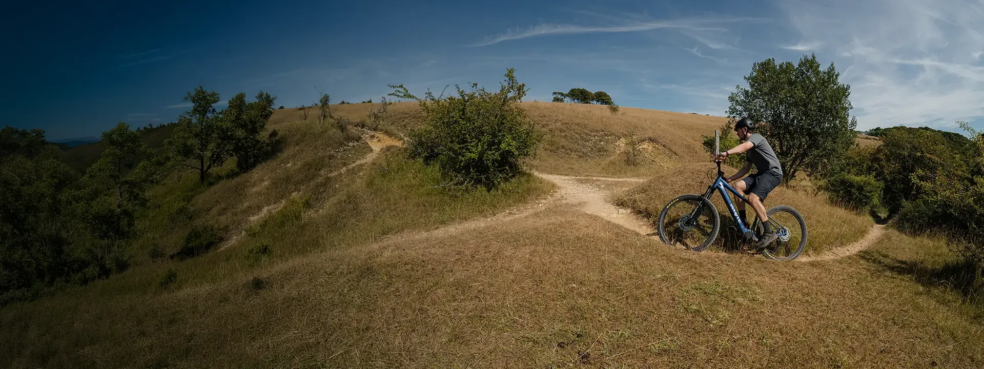 Rider exploring a dry countryside trail on a hardtail electric mountain bike