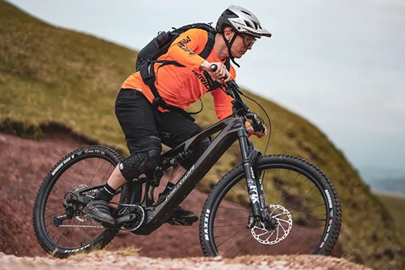 riding an electrci mountian bike with meandering river in background