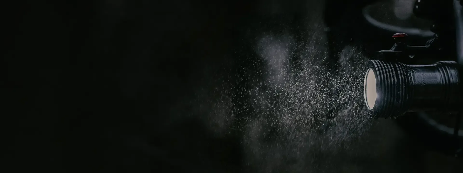 Close-up of an Exposure bike light illuminating water droplets in the dark