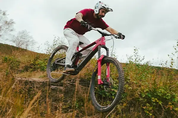 Mike Jones riding the Forbidden Dreadnought E on a downhill traiil in the woods