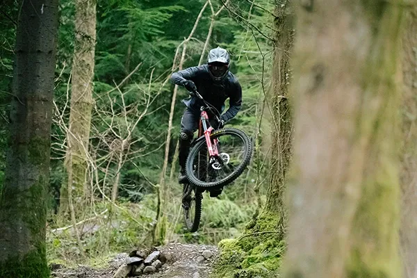 Forbidden Dreadnought E hard charging jump on trail in woods